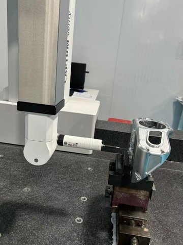 CMM probe tip contacting the surface of a machined housing during a GD&T measurement