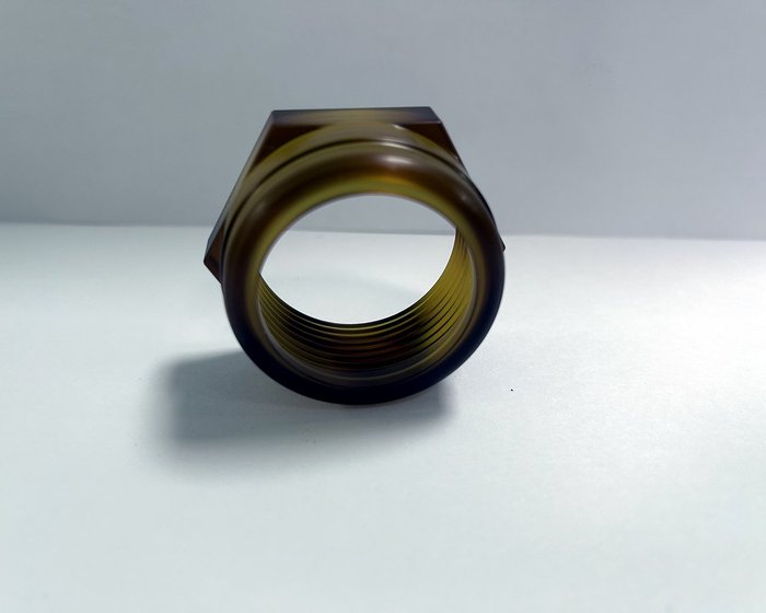 A threaded PEEK ring sample. Thread crests on polymers tear easily, so the job runs with fresh tool edges and light finishing passes.