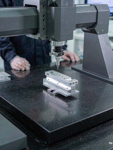 CMM probe verifying an aluminum semiconductor part on a granite inspection table