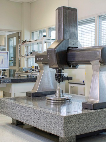 Hexagon bridge CMM measuring an aluminum medical device housing in a clean quality control lab