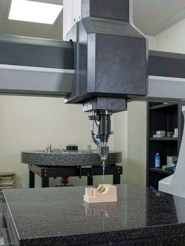 Hexagon bridge CMM verifying dimensional accuracy of a machined PEEK part