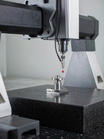 Bridge CMM probing the sealing flange of a machined sensor housing on a granite table