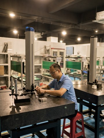 Inspector verifying a machined part with a height gauge at an inspection bench
