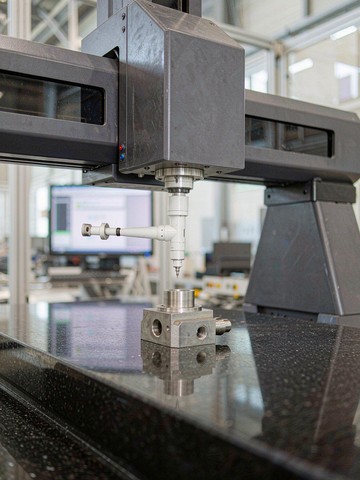 Bridge CMM probing an Inconel 718 part on a granite surface plate at the KGL inspection lab