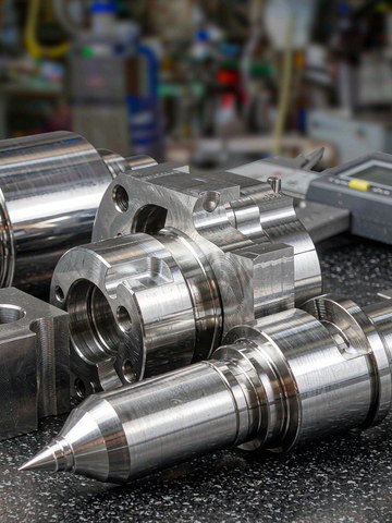 Mold inserts and slide components made of polished tool steel on a granite surface