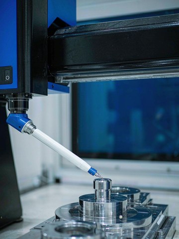 CMM probe verifying a 316 stainless steel machined fitting on a granite inspection table