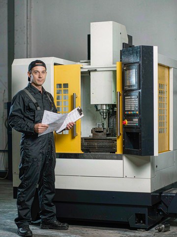 Machining facility floor with rows of white and dark blue CNC machining centers in operation
