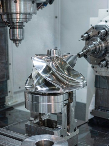 Complex impeller with twisted blades finished on a five-axis machining center, a geometry class that requires simultaneous multiaxis motion.