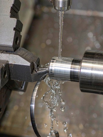 CNC turning a steel shaft to a mirror-bright finish, fine feed and sharp tooling produce the low Ra value.