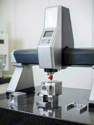 Bridge CMM verifying critical features of a tightly toleranced part in a temperature controlled inspection room.
