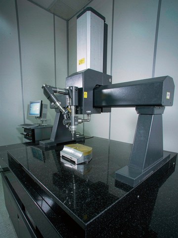 Bridge CMM with granite table verifying critical features of a machined housing in a temperature-controlled inspection room.