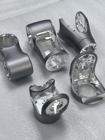 Machined dual-arm robot wrist housing with mounting bosses